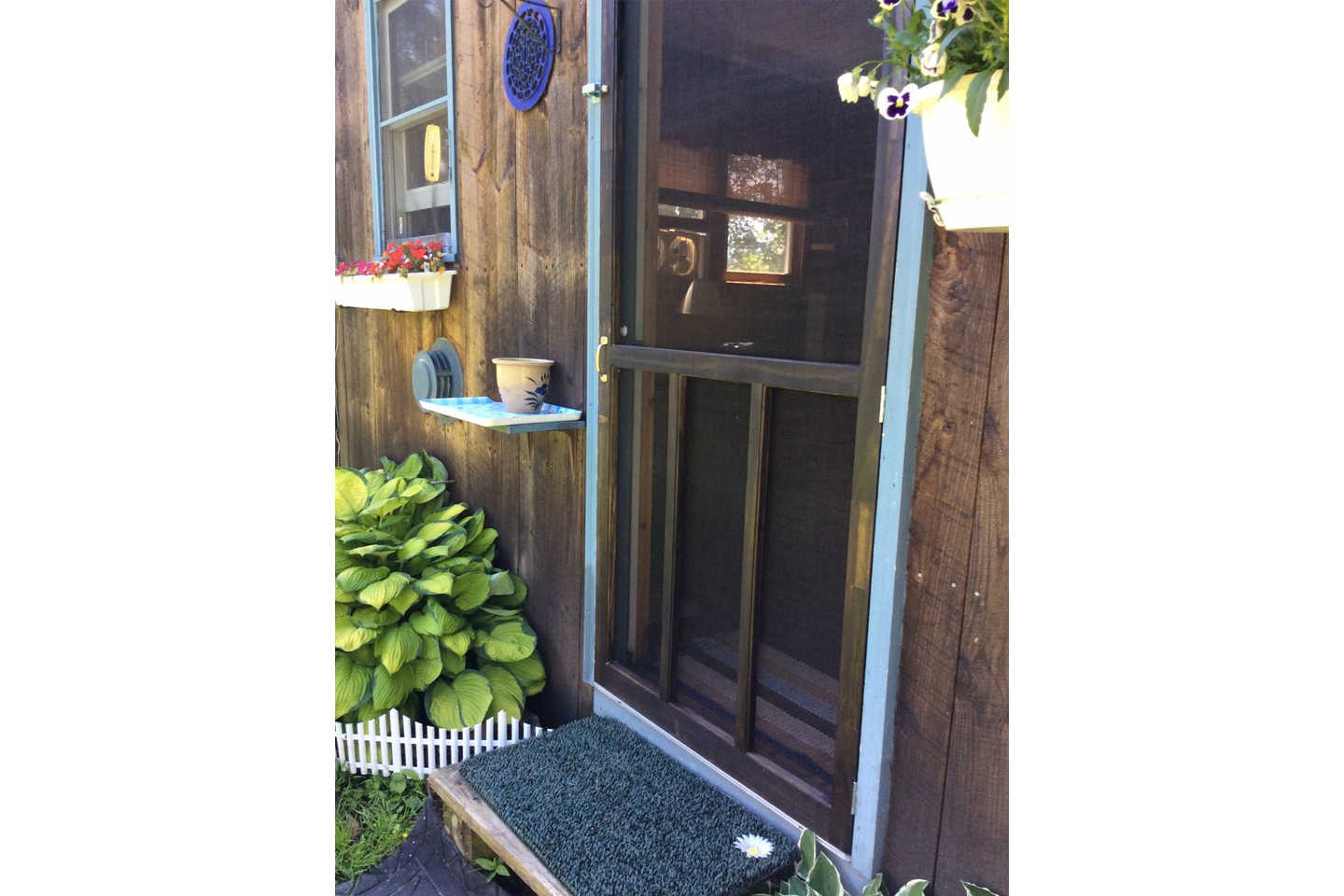 The screen door adds sunlight, views and fresh air into the Rustic Cabin